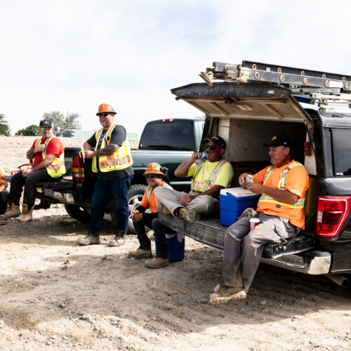 OSWCA, employees sitting around trucks at dirt worksite, lunch, break, 24053_BUILDWITT_2725