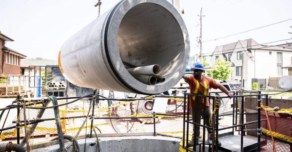 OSWCA, employee, blue hard hat, guiding pipe being lowered, residential, 24067_BUILDWITT_1260